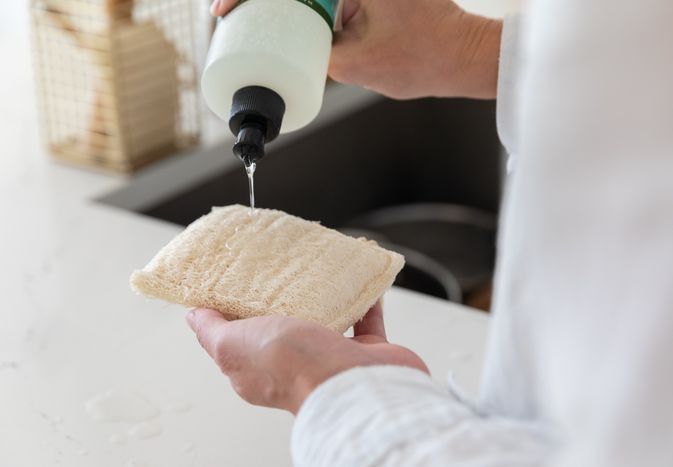 adding cleaner to a sponge