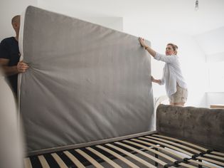 A couple moving a mattress.
